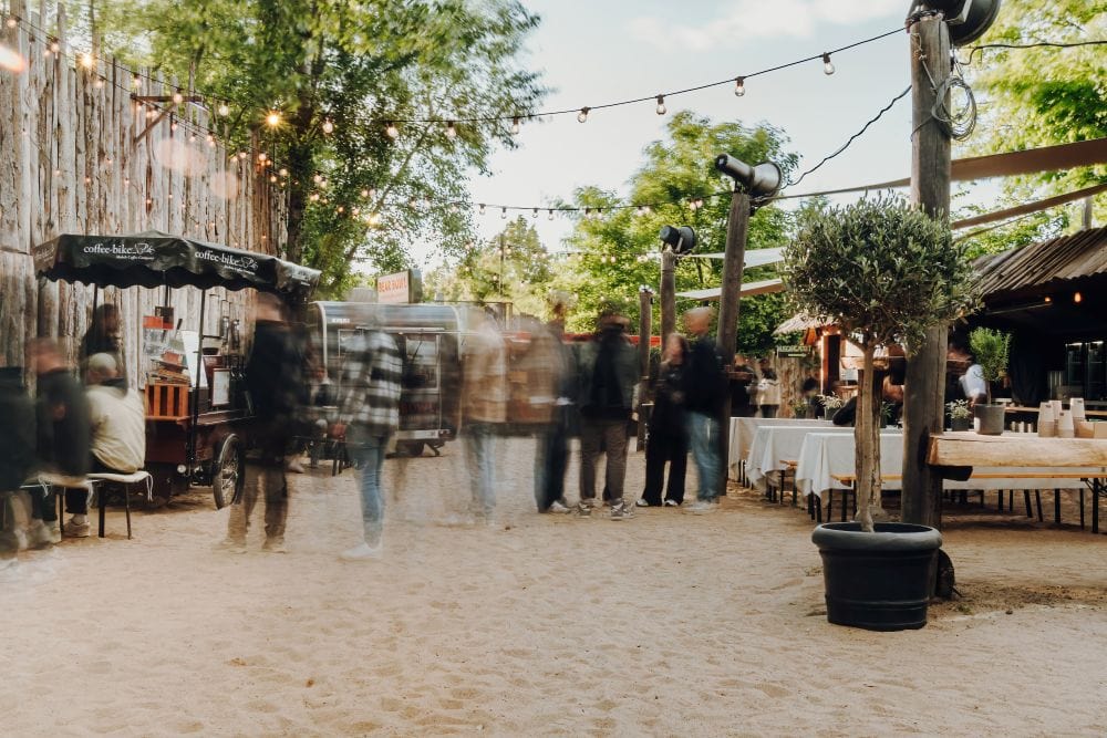 Gemütliche Outdoor-Eventlocation in Leipzig mit Sandboden und festlicher Beleuchtung.